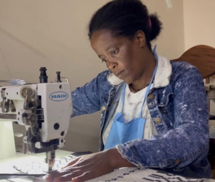 Ethiopian artisan using sewing machine to make leather goods.